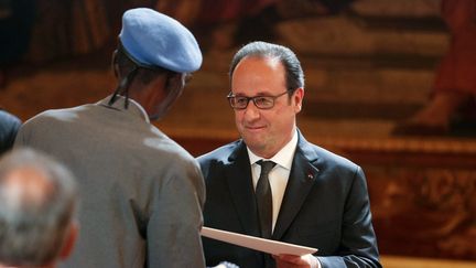 François Hollande salue un vétéran durant une cérémonie de naturalisation d'anciens tirailleurs sénagalais, à l'Elysée, le 15 avril 2017.  (GEOFFROY VAN DER HASSELT / AFP)