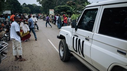 Un véhicule des Nations Unies traverse la foule sur les lieux&nbsp;d'une attaque, où au moins 5&nbsp;personnes&nbsp;ont été tuées. Elle est le fait de rebelles dans le disctrict de Masiani, à Beni (RDC), le 23 décembre 2018.&nbsp; (ALEXIS HUGUET / AFP)