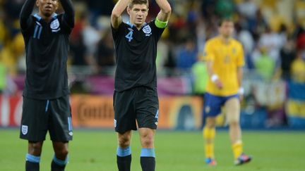 Le milieu de terrain Steven Gerrard et l'attaquant Ashley Young c&eacute;l&egrave;brent la victoire de l'Angleterre (3-2) contre la Su&egrave;de, le 15 juin 2012 &agrave; Kiev en Ukraine.&nbsp; (JEFF PACHOUD / AFP)