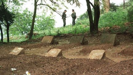 Une photo datant de mai 1997, sur laquelle des soldats alg&eacute;riens gardent les tombes des sept moines, &agrave; Tib&eacute;hirine (Alg&eacute;rie). ( AFP )