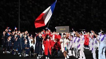 La France a défilé en avant dernier, juste après les États-Unis et avant le Japon, le pays hôte (la France et les États-Unis sont les prochaines nations à accueillir l'événement). La délégation française, emmenée par les deux porte-drapeaux Stéphane Houdet et Sandrine Martinet, a défilé en respectant l'ordre des couleurs du drapeau national.&nbsp; (PHILIP FONG / AFP)