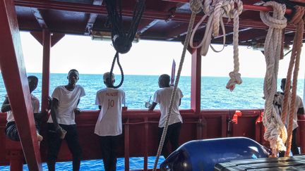 Des migrants sauvés attendent sur le pont du navire de sauvetage "Ocean Viking", le 20 août 2019. (ANNE CHAON / AFP)