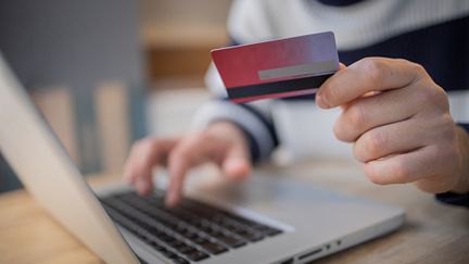 Homme rensiegnant ses donnés bancaires sur son ordinateur. (ROCKAA / GETTY IMAGES)