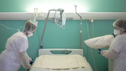 Des aides-soignantes nettoient la chambre d'un patient Covid, le 26 janvier 2021, à l'hôpital de Perpignan (Pyrénées-Orientales). (IDHIR BAHA / HANS LUCAS / AFP)