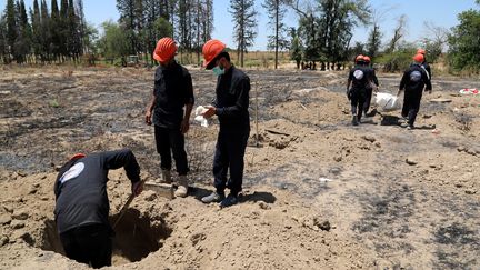 Des enquêteurs fouillent un site près de Raqqa dans le nord-est de la Syrie où près de 200 corps ont été retrouvés (7 juillet 2019). (AHMED MARDNLI / EPA)