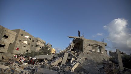 Un Palestinien observe les d&eacute;combres d'une maison d&eacute;truite par une frappe isra&eacute;lienne, dans le nord de Gaza, le 15 juillet 2014. (MAHMUD HAMS / AFP)