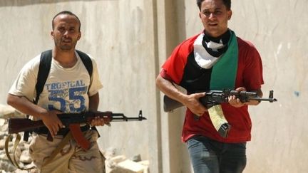 Deux rebelles patrouillent dans les rues de Zaouïah. (MARC HOFER / AFP)