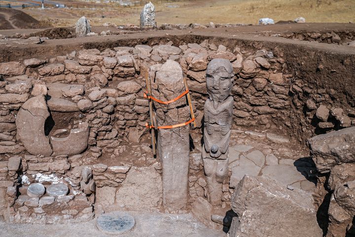 La statue de l'homme de pierre assis, empoignant son sexe à deux mains, un vautour à ses pieds, sur le site archéologique de.Karahantepe en Turquie le 23 octobre 2023 (OZAN KOSE / AFP)