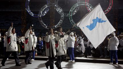 Des athlètes des deux Corées défilent ensemble sous le drapeau de la péninsule unie lors de la cérémonie d'ouverture des Jeux olympiques d'hiver de Turin (Italie), le 10 février 2006. (DYLAN MARTINEZ / REUTERS)