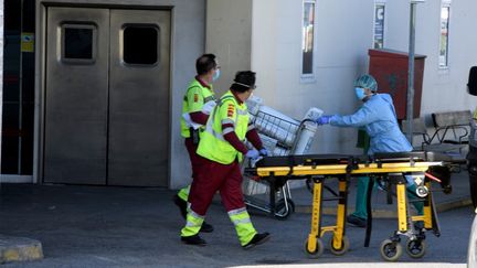 Du personnel médical transporte un patient aux urgences de l'hôpital de Madrid (Espagne), le 26 mars 2020. (JUAN CARLOS LUCAS / NURPHOTO / AFP)