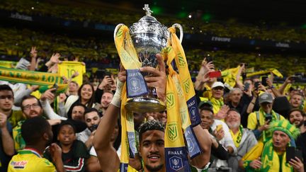 Ludovic Blas, capitaine du FC Nantes, soulève la Coupe de France devant les tribunes du Stade de France à Saint-Denis (Seine-Saint-Denis) après la victoire de son équipe en finale, le 7 mai 2022. (FRANCK FIFE / AFP)