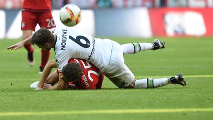 Harvard Nordveit (Borussia Moenchengladbach) se couche sur Thomas Müller (Bayern Munich) (CHRISTOF STACHE / AFP)