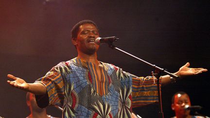 Le chanteur sud-africain Joseph Shabalala, fondateur de l'ensemble vocal sud-africain Ladysmith Black Mambazo, en concert le 1er août 2002 à Johannesburg (ALEXANDER JOE / AFP)