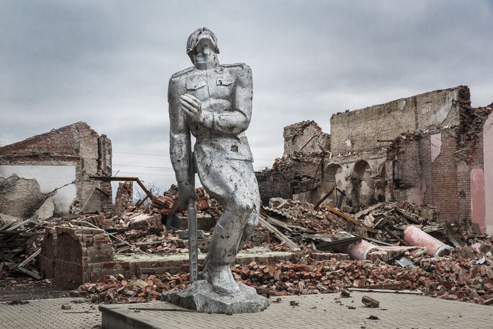 Une sculpture de la ville ukrainienne d'Avdiivka, devant des bâtiments détruits lors de la guerre entre l'Ukraine et la Russie, le 4 décembre 2023. (MAREK M. BEREZOWSKI / ANADOLU / AFP)