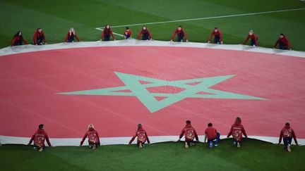 Un drapeau marocain étendu sur la pelouse du stade de&nbsp;Kaliningrad lors de la Coupe du monde en Russie, le 25 juin 2018. (OZAN KOSE / AFP)