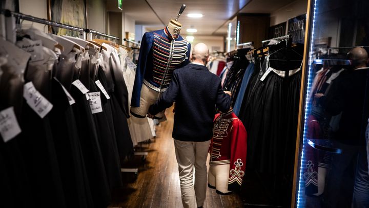 Un employé transporte deux costumes réalisés pour Le Rouge et le noir de Pierre Lacotte en 2021. (MARTIN BUREAU / AFP)