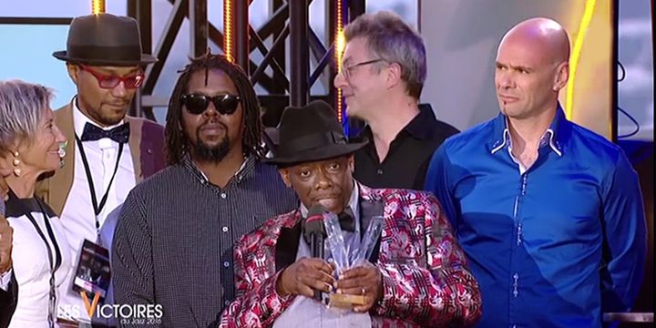 Lucky Peterson (au centre), sa Victoire d'honneur en main, entouré de ses musiciens et de son équipe
 (Capture d&#039;écran / Victoires du Jazz / France 3)