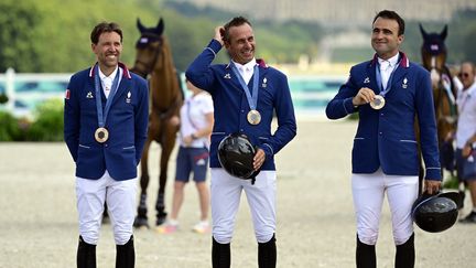 Simon Delestre (à gauche), Julien Epaillard (au centre) et Olivier Perreau ont apporté une deuxième médaille à l'équitation française, vendredi 2 août, au concours de saut d'obstacles par équipes. Septièmes des qualifications, les cavaliers français et leurs chevaux ont sorti le grand jeu en finale, ne faisant tomber qu'une seule barre sur leurs trois passages et ont pris le bronze derrière les Britanniques et les Américains. (DIRK WAEM / AFP)