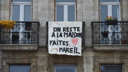 Des habitants de Bordeaux (Gironde) ont affiché une banderole sur leur balcon à destination de la population pour lutter contre le coronavirus, le 16 mars 2020. (NICOLAS TUCAT / AFP)