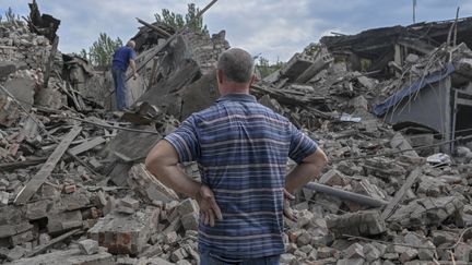 Un habitant de Toretsk (Ukraine) devant un immeuble en ruines, le 5 août 2022.&nbsp; (BULENT KILIC / AFP)