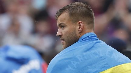 La star ukrainienne de West Ham Andriy Yarmolenko avec le drapeau de son pays autour des épaules, lors du dernier match de championnat de la saison face à Manchester City, le 15 mai 2022. (IAN KINGTON / IKIMAGES / AFP)