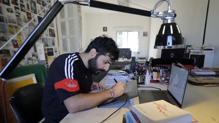 Le caricaturiste libanais Bernard Hage travaille dans son studio à Jal el-Dib, dans la banlieue nord de la capitale Beyrouth. (JOSEPH EID / AFP)