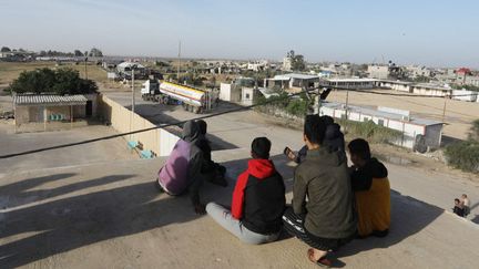 Des Palestiniens voient arriver des camions amenant du carburant dans la bande de Gaza, le 24 novembre 2023 à Rafah. (ABED RAHIM KHATIB / ANADOLU / AFP)