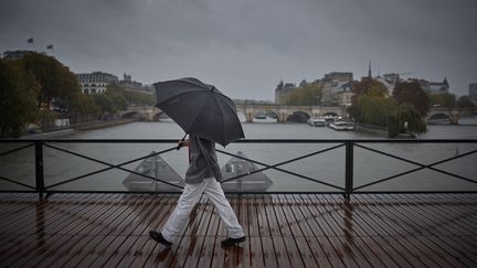 Un passant sur le pont des Arts à Paris, le 9 octobre 2024 à Paris. (KIRAN RIDLEY / AFP)