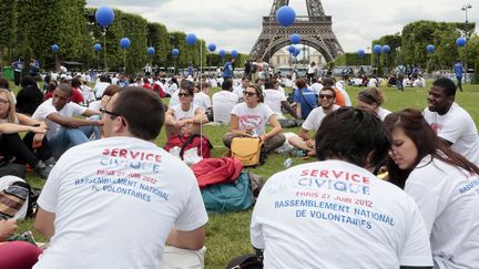 Des jeunes engag&eacute;s&nbsp;dans le service civique, sur la pelouse du Champs-de-Mars, pr&egrave;s de la tour Eiffel &agrave; Paris, le 27 juin 2012. (JACQUES DEMARTHON / AFP)