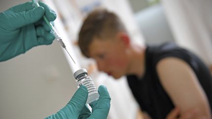 Un adolescent s'aprrête à être vacciné contre le Covid-19 à Munich, en Allemagne, le 27 mai 2021. (FRANK HOERMANN / SVEN SIMON / AFP)