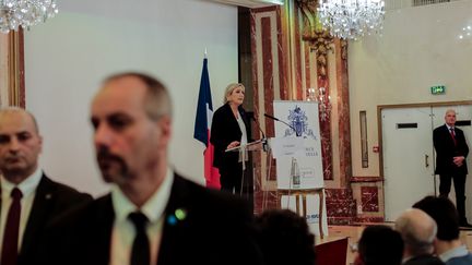 Des agents assurent la sécurité&nbsp;de Marine Le Pen lors d'une déclaration à Paris, le 13 mars 2017. (SADAK SOUICI / CITIZENSIDE / AFP)