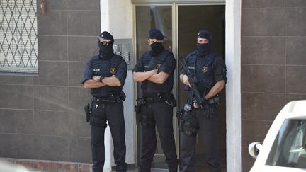 Des membres des&nbsp;Mossos d'Esquadra, la polie régionale catalane, devant l'appartement du suspect ayant attaqué un commissariat à Cornellà de Llobregat (Catalogne, Espagne), le 20 août 2018. (LLUIS GENE / AFP)