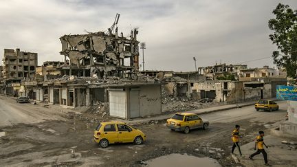 Des enfants travesent une rue détruite par les bombardements dans Raqqa, l'ancienne capitale de l'Etat islamique, le 1er mai 2019. (DELIL SOULEIMAN / AFP)