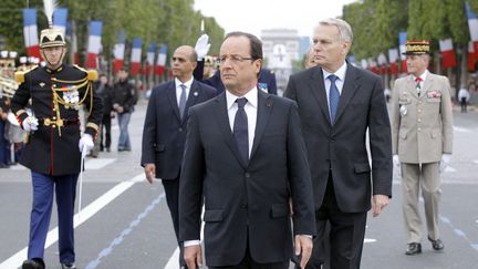 Le pr&eacute;sident Fran&ccedil;ois Hollande accompagn&eacute; du Premier ministre Jean-Marc Ayrault lors du d&eacute;fil&eacute; du 14-Juillet sur les Champs-Elys&eacute;es &agrave; Paris. (BENOIT TESSIER / POOL)