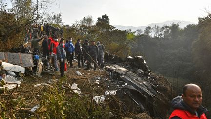 Les secours sur les lieux du crash d'un avion de la compagnie Yeti Airlines, près de Pokhara, au Népal, le 15 janvier 2023. (PRAKASH MATHEMA / AFP)