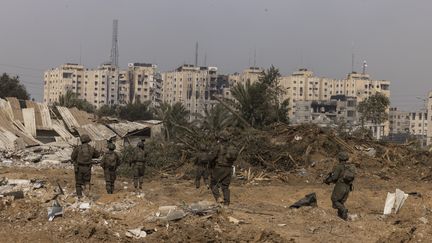 Des soldats israéliens sur une photo prise lors d'une tournée médiatique organisée par l'armée israélienne, le 8 janvier 2024, dans la région d'al-Bureij, dans le centre de la bande de Gaza. (MENAHEM KAHANA / AFP)