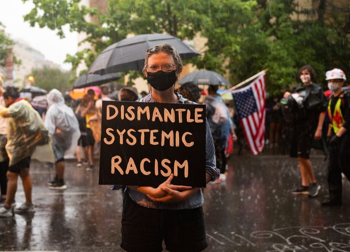 Une personne porte une pancarte contre le "racisme systémique" près de la Maison Blanche à Washington (Etats-Unis), lors d'une manifestation contre les violences policières et le racisme, le 5 mai 2020. (ZACH D ROBERTS / NURPHOTO)