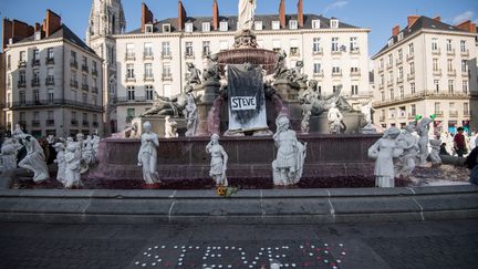 Une fontaine à Nantes où des bougies ont été déposées au sol, le 30 juillet.&nbsp; (LOIC VENANCE / AFP)