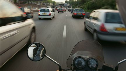 Un motard remonte une file de voitures sur le p&eacute;riph&eacute;rique parisien. (PIERRE-FRANCK COLOMBIER / AFP PHOTO)