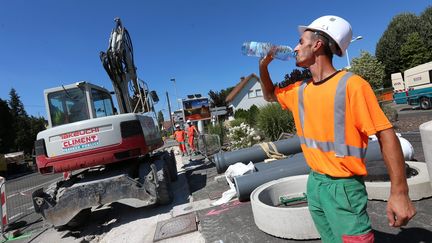 Des ouvriers d'une entreprise de BTP travaillent sur un chantier sous le soleil, le 26 juillet 2018 (LIONEL VADAM  / MAXPPP)