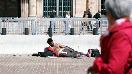 Un sans domicile fixe est allongé sur le sol dans une rue de Marseille, le 7 mai 2019. (NICOLAS VALLAURI / MAXPPP)