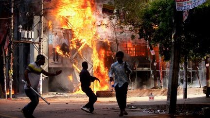 Un magasin de vêtements incendié dans le cadre des manifestations à Dacca (Bangladesh), le 4 août 2024 (ABU SUFIAN JEWEL / AFP)