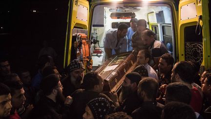 Des hommes évacuent des corps, quelques heures après l'attaque sanglante à Minya (Egypte), le 26 mai 2017. (IBRAHIM EZZAT / NURPHOTO / AFP)