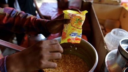 Un jeune Indien pr&eacute;pare des nouilles instantan&eacute;es Maggi fabriqu&eacute;es par Nestl&eacute;, le 3 juin 2015 &agrave; New Delhi. (CHANDAN KHANNA / AFP)