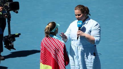 L'ancienne joueuse Jelena Dokic interviewe la Polonaise Magda Linette, lors de sa victoire contre Caroline Garcia à l'Open d'Australie, le 23 janvier 2023. (MARTIN KEEP / AFP)