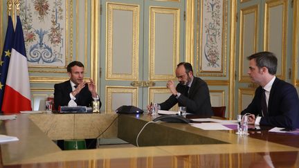 Emmanuel Macron, Édouard Philippe et Olivier Véran à l'Élysée, en mars 2020. (LUDOVIC MARIN / POOL / MAXPPP)