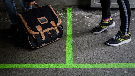 Un marquage au sol vert indique aux écoliers&nbsp;la distance à respecter, le 12 mai 2020, à Paris.&nbsp; (PHILIPPE LOPEZ / AFP)