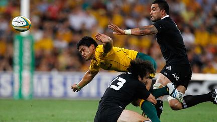 Ben Tapuai (Australie) plaqué par le All Black Conrad Smith sous le regard de Liam Messam (Nouvelle-Zélande)