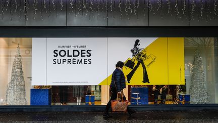 Une piétonne passe devant un panneau publicitaire dans les rues de Caen, le 8 janvier 2020. (SAMEER AL-DOUMY / AFP)