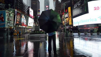 Seuls de rares touristes s'aventurent &agrave; Times Square, offrant un calme irr&eacute;el &agrave; ce quartier d'ordinaire tr&egrave;s passant. (TIMOTHY A. CLARY / AFP)